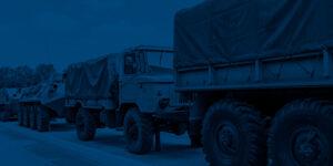 Military trucks and armoured vehicles parked in a row